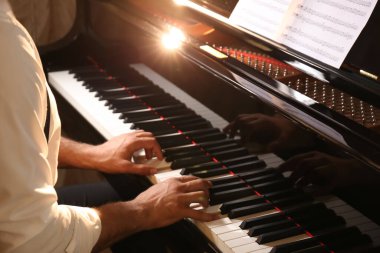 Man playing piano indoors, closeup. Talented musician clipart