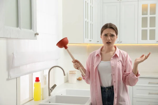 Mutfaktaki Tıkanmış Lavabonun Yanında Pompası Olan Üzgün Genç Bir Kadın — Stok fotoğraf