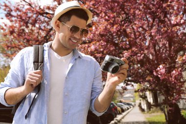 Şehir caddesinde yürüyen kameralı bir turist