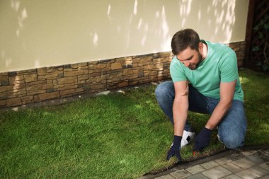 Arka bahçede çimen biçen genç adam, mesaj için yer var.