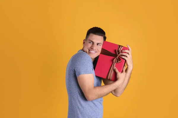 Greedy Man Hiding Gift Box Yellow Background Space Text — Stock Photo, Image