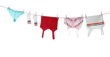 Temiz giysiler beyaz arka planda çamaşır ipine asılı.