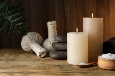 Güzel bir spa kompozisyonu, yanan mumlar ve ahşap masada deniz tuzu.