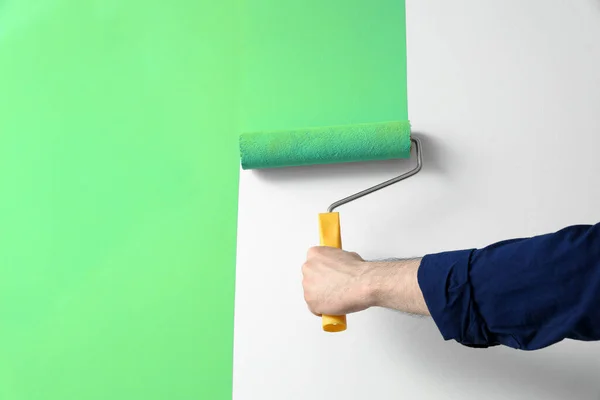 Mann Trägt Hellblaue Farbe Mit Rollerpinsel Auf Weiße Wand Auf — Stockfoto