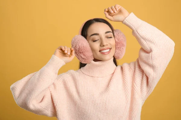 Hermosa Mujer Joven Con Orejeras Sobre Fondo Amarillo —  Fotos de Stock