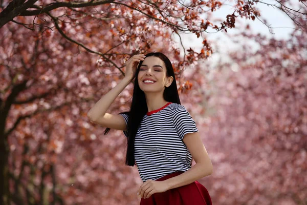 Söt Ung Kvinna Bär Trendiga Kläder Nära Vackra Blommande Träd — Stockfoto