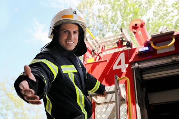 Пожежник Формі Шоломі Пропонує Руку Біля Пожежної Машини Відкритому Повітрі — стокове фото
