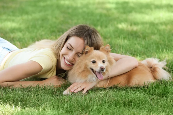 若いです女性とともに彼女の可愛いです犬上の緑の草で公園 — ストック写真