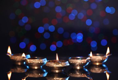Karanlık arka planda bulanık ışıklarla aydınlatılmış diyadalar, metin için boşluk. Diwali lambaları