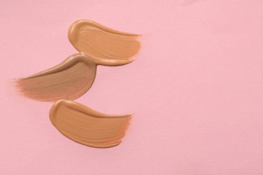 Pembe arka planda sıvı deri örnekleri, üst manzara. Metin için boşluk