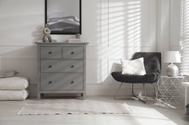 Gri çekmeceleri ve rahat koltukları olan şık bir oda.