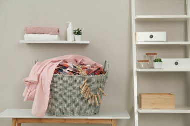 Kirli çamaşırlar ve kapalı masa üzerindeki mandallarla dolu bir sepet.