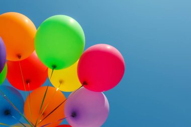 Mavi gökyüzüne karşı renkli balonlar, alçak açı. Metin için boşluk