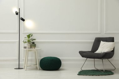 Pouf, sandalye ve ev bitkileriyle süslü bir oda. Metin için boşluk