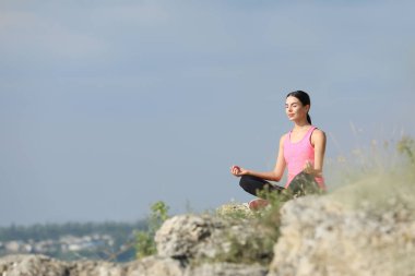 Cliff 'te meditasyon yapan genç bir kadın. Metin için boşluk
