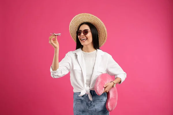 Glückliche Touristin Mit Spielzeugflugzeug Und Reisekissen Auf Rosa Hintergrund — Stockfoto