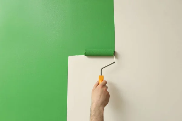 Mann Trägt Grüne Farbe Mit Rollerpinsel Auf Weiße Wand Auf — Stockfoto