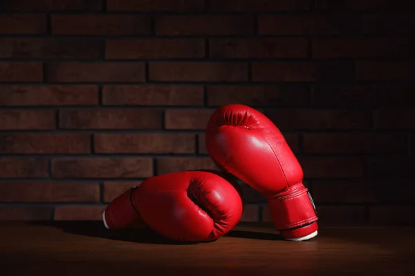 Par Röda Boxningshandskar Träbord Nära Tegelvägg — Stockfoto