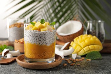 Mangolu lezzetli chia pudingi, nane ve granola gri masada, metin için yer var.