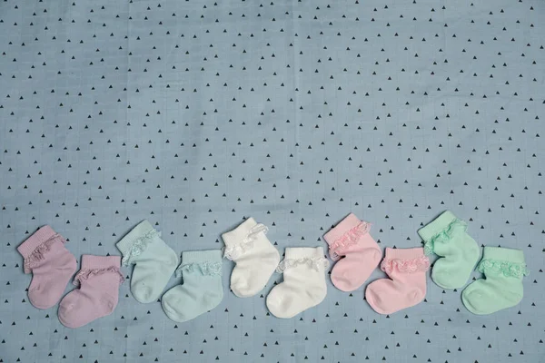 Muitas Meias Bebê Coloridas Tecido Azul Claro Flat Lay Espaço — Fotografia de Stock