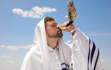 Tallit 'te Yahudi bir adam açık havada hava üflüyor. Rosh Hashanah kutlaması