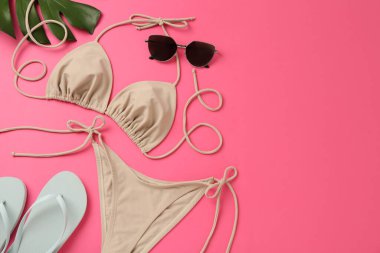 Pembe arka planda şık bikinili düz kompozisyon. Metin için boşluk