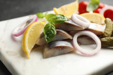 Dilimlenmiş balık fileto, fesleğen, soğan halkaları, turşu ve limon ile servis masası, yakın plan.