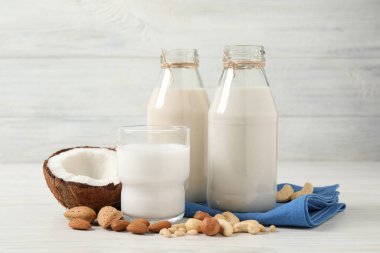 Beyaz ahşap masada farklı fındık sütleri