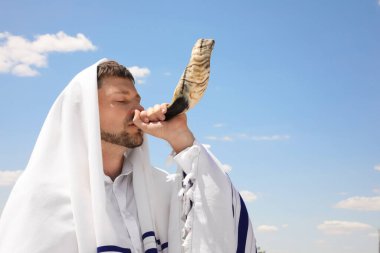 Tallit 'te Yahudi bir adam açık havada hava üflüyor. Rosh Hashanah kutlaması