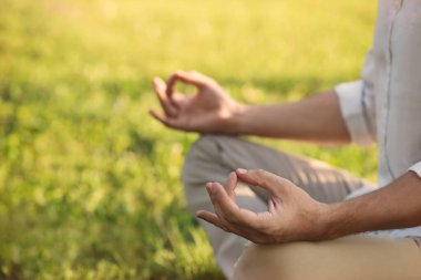 Güneşli bir günde meditasyon yapan bir adam, yakın plan. Metin için boşluk