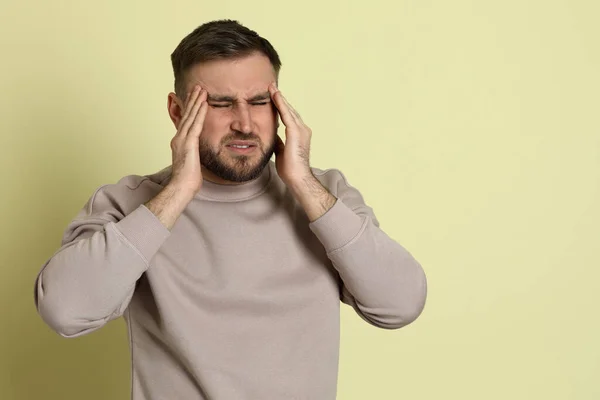 Uomo Che Soffre Emicrania Sfondo Verde Chiaro Spazio Testo — Foto Stock