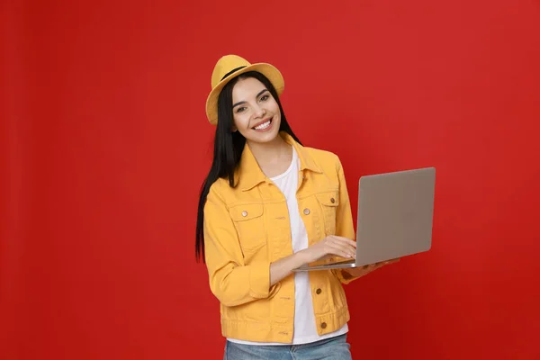 Mujer Joven Con Portátil Moderno Sobre Fondo Rojo — Foto de Stock