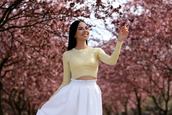 Söt Ung Kvinna Bär Trendiga Kläder Nära Vackra Blommande Träd — Stockfoto