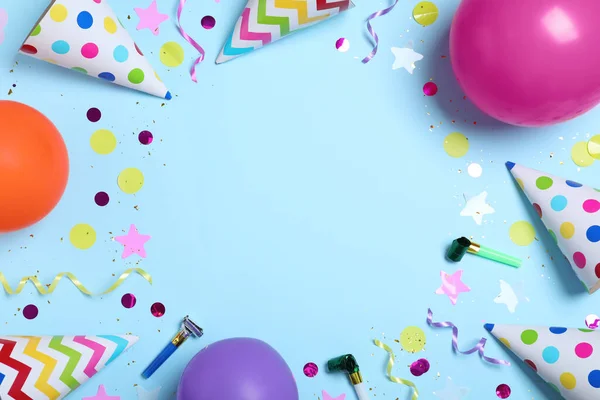 ライトブルーの背景にパーティー帽子と誕生日の装飾で作られたフレーム フラットレイ テキストのスペース — ストック写真