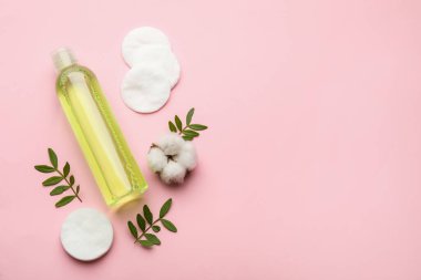 Pamuk pedler, çiçek, yapraklar ve makyaj malzemesi pembe arka planda, düz yerde. Metin için boşluk