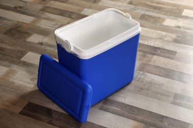 Ahşap zeminde açık mavi plastik kutu