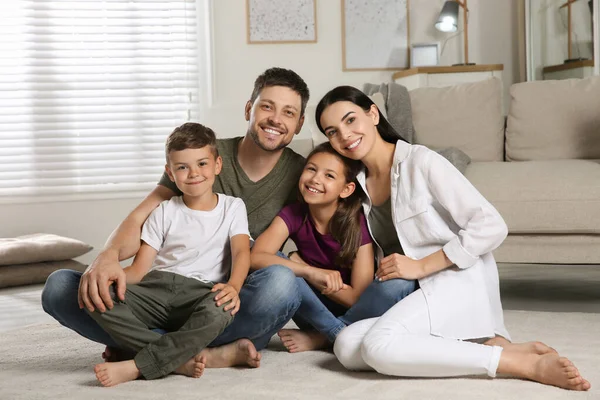 Portrait of happy family in living room. Adoption concept