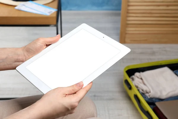 Mujer Usando Tableta Moderna Mientras Empaca Maleta Para Las Vacaciones — Foto de Stock