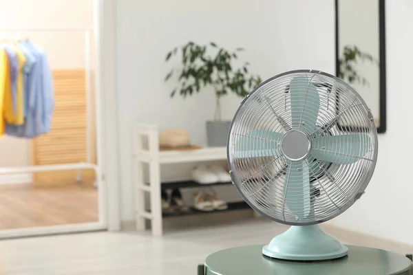 Modern electric fan on table in room, space for text