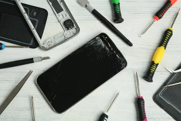 Κατεστραμμένο Smartphone Και Εργαλεία Επισκευής Λευκό Ξύλινο Φόντο Επίπεδη Lay — Φωτογραφία Αρχείου