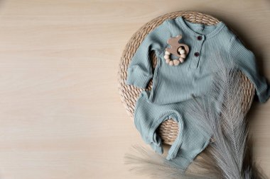 Bebek tulumu, oyuncak ve tüy tahta arka planda, düz yerde. Metin için boşluk