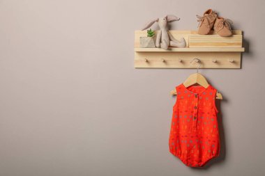 Bebek giysisi, patik ve oyuncaklar ahşap rafta. Metin için boşluk