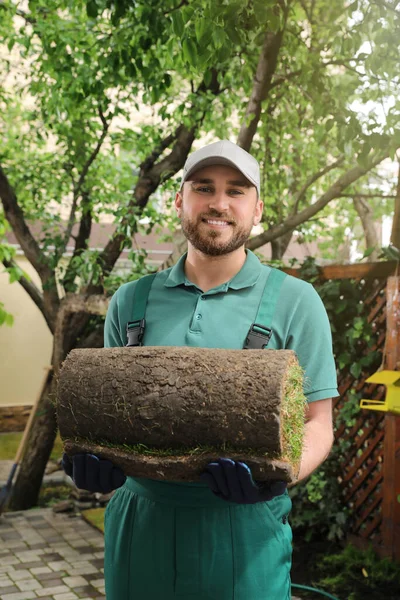 Joven Trabajador Sosteniendo Césped Laminado Patio Trasero — Foto de Stock