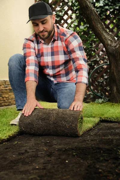 Genç Adam Çimenleri Arka Bahçeye Seriyor — Stok fotoğraf
