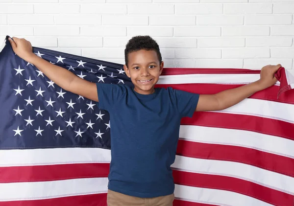Feliz Niño Afroamericano Sosteniendo Bandera Nacional Cerca Pared Ladrillo Blanco — Foto de Stock
