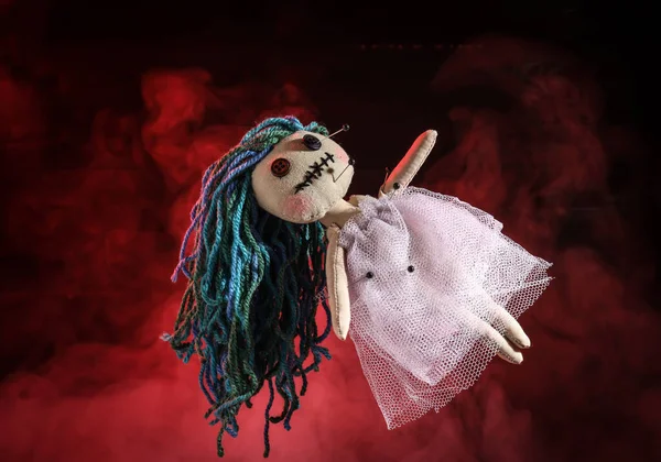 红色背景下带有针头和烟雾的女巫女娃娃 — 图库照片