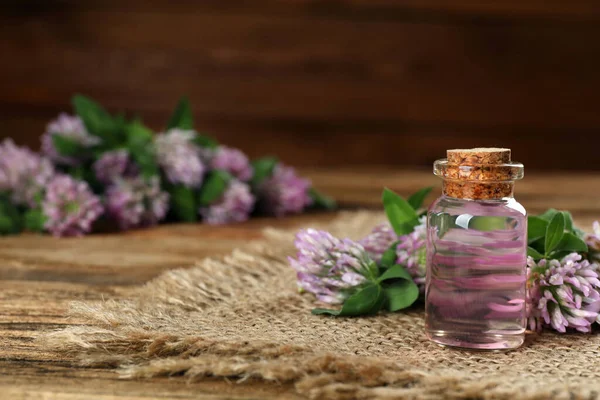 Schöne Kleeblumen Und Eine Flasche Ätherisches Auf Einem Holztisch Platz — Stockfoto