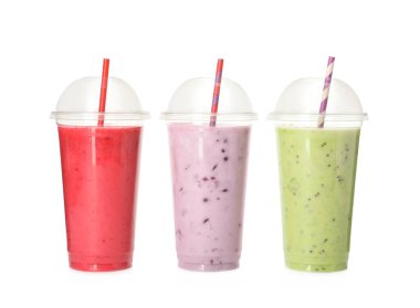 Beyaz arkaplanda plastik bardaklarda pipetle farklı smoothie 'ler