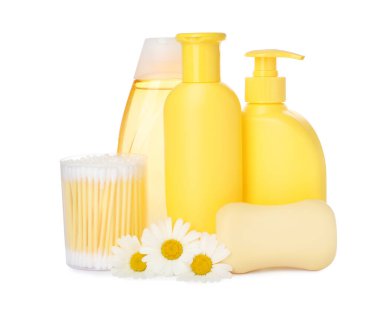 Bebek kozmetik ürünleri seti, papatya çiçekleri ve beyaz arka planda pamuk örnekleri.