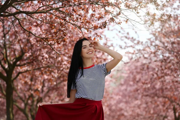 Söt Ung Kvinna Bär Trendiga Kläder Nära Vackra Blommande Träd — Stockfoto